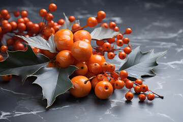 Close up of glossy orange berries and green holly leaves on dark marble background. Festive Christmas or Autumn decoration flat lay. Seasonal nature concept with copy space