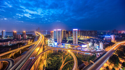 Aerial Urban Nightscape with Illuminated Highways and Bustling Business District © TranPhuoc