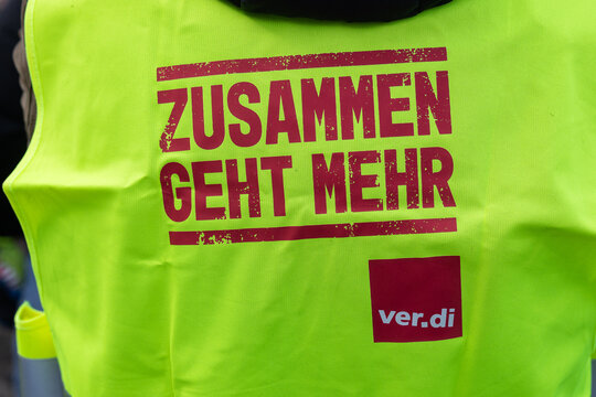 Detailaufnahme einer gelben Warnweste mit dem Aufdruck &bdquo;Zusammen geht mehr&ldquo; und dem Verdi-Logo, getragen w&auml;hrend des Warnstreiks von Besch&auml;ftigten des Staatstheaters N&uuml;rnberg vor der Kongresshalle.