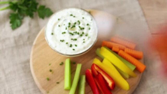 Delicious Kr?uter Dip with Fresh Vegetable Sticks on a Wooden Board close up