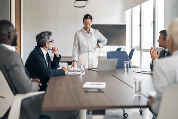 Smiling asian businesswoman leading meeting and presentation in office