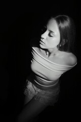 Naklejka premium Black and white photos of a girl on a black background. Beautiful young model