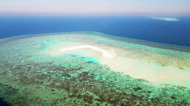 Aerial drone view of desert mountain landscape in A lUla Saudi Arabia, cinematic landscape of ancient rock formations and red sand dunes at golden hour.