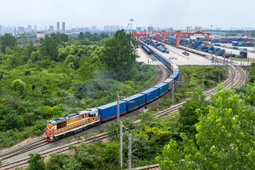 Freight Train Through Industrial Rail Junction with Port Containers