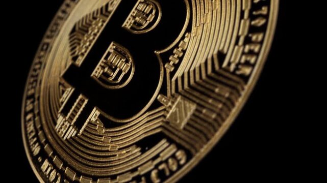 Close up of a golden Bitcoin cryptocurrency coin spinning on a black background, concept for digital finance and investment.