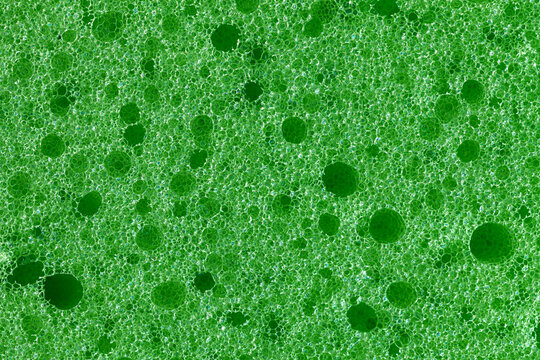 Close-up of green foam with varied bubble sizes. Ideal for cleaning, science, and abstract design themes.