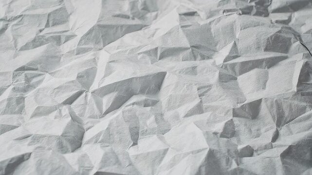 Abstract texture of crumpled paper with sharp folds and soft light