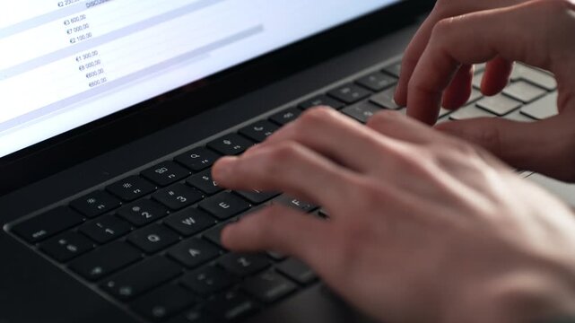 Fingers Tapping on the Keyboard, a Spreadsheet with Numbers Displays on the Bright Screen of the Laptop, Close Up, Slow Motion