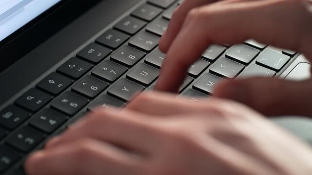 Alphanumeric Keys of the Laptop Keyboard Being Tapped by Fingers - Letters and Numbers are in Focus, the Hands Are Blurred