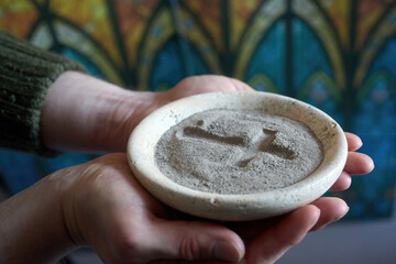 Hands holding ash wednesday ashes with cross symbol