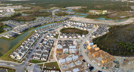 Obraz premium Wooden houses under construction in new developing suburban area. Development of residential housing in American suburbs. Real estate market in the USA