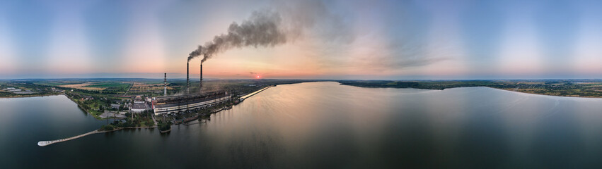 Aerial view of coal power plant high pipes with black smokestack polluting atmosphere. Electricity production with fossil fuel concept