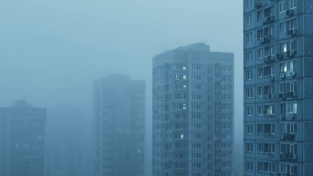 Empty modern city skyline swallowed by dust and haze, broken windows reflecting dull light. No signs of life remain, creating a vast, cinematic vision of post-war silence and urban desolation.
