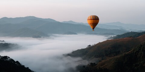 Obraz premium Vibrant hot air balloon over misty mountain landscape at sunrise