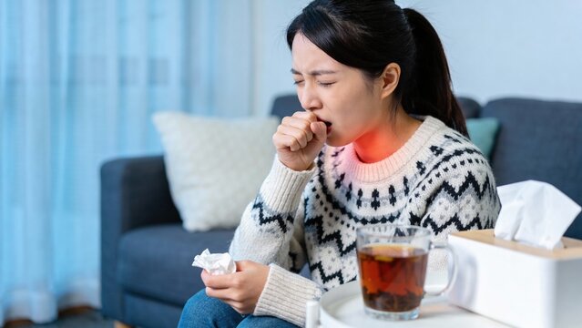 People sick in winter season, Young Asian woman coughing and feeling sore in her throat with highlighted.