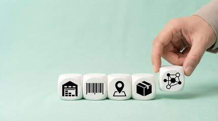 Hand placing network icon cube with warehouse barcode location and package blocks on mint background minimalist inventory tracking distribution technology with copy space