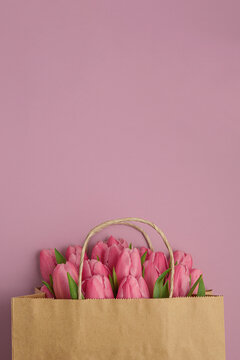 Gift Bag with Pink Tulips on Pink Background. Valentine's or Mother's Day Celebration