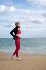 sporty woman jogger resting after exercise, running on the beach