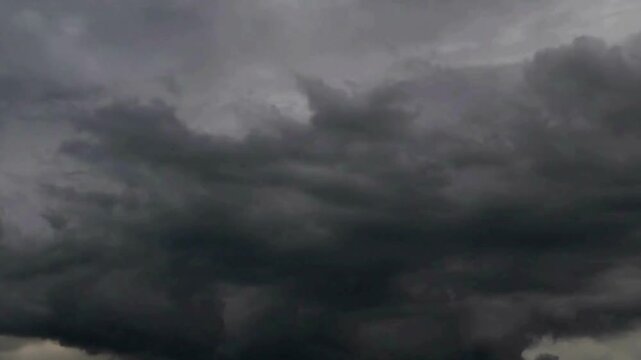 Heavy looming storm with towering dark cumulonimbus clouds rolling in, capturing the dramatic atmosphere and raw power of an impending thunderstorm. Climate Change, and the Raw Power of Nature.