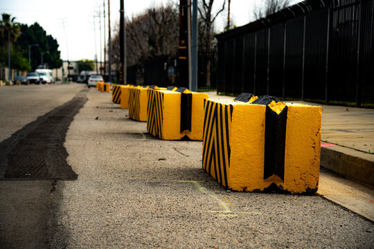 Yellow and black concrete barriers line a street, indicating a restricted area or construction zone