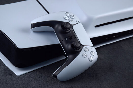 Kharkiv, Ukraine - July 10, 2025: The white Sony Play Station 5 and controller on the dark table.