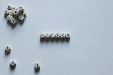 Vision spelled with letter blocks symbolizing foresight, goals, and strategic thinking in a clean minimalist layout with copy space.