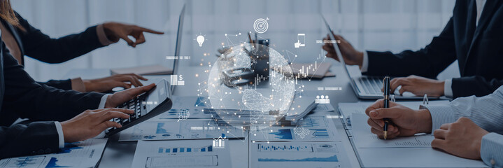 A collaborative business meeting showcasing diverse professionals analyzing data on laptops, discussing strategies, and visualizing growth through digital graphics in a modern office. Trope