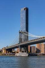 Obraz premium Boat on the East River in front of Manhattan Bridge and One Manhattan Square.