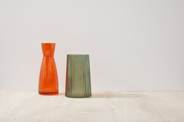Contemporary Orange and Green Glass Vases on Light Wooden Surface