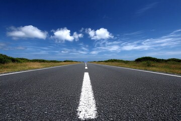 Wide road stretches into the distance under blue skies