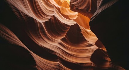 Eroded sandstone walls form a winding, sunlit canyon, revealing layered textures and shadows