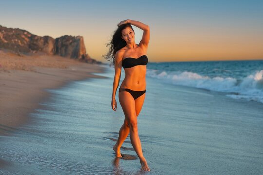 Athletic Woman With Fit Body Smiling In Black Bikini Swimsuit On Tropical Beach During Summer Vacation