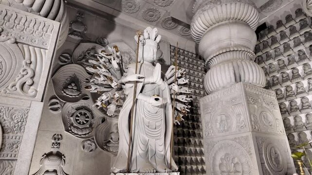 White Stone Statue of Multi-Armed Deity in Intricate Temple Interior