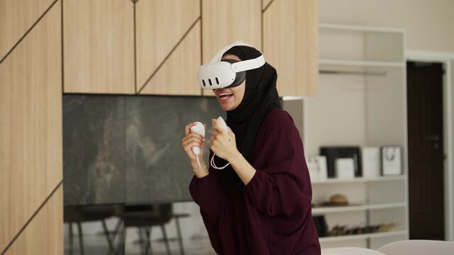 Muslim woman in traditional wear playing VR boxing game using controllers