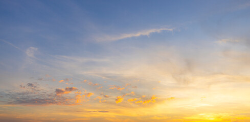 Golden sunset sky with soft orange clouds and blue gradient background,A breathtaking panoramic view of the evening sky during sunset, featuring a vibrant blend of golden yellow, warm orange,