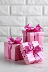 Obraz premium Pink gift boxes with ribbons on white brick background