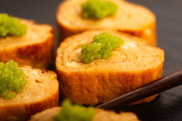 Japanese Tamagoyaki with Green Wasabi Caviar on Black Stone Board
