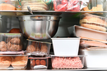 An open refrigerator filled with packaged containers of food, meat, bread, and ready-made meals. A concept for food storage, home kitchen organization, groceries, freshness, and everyday lifestyle.