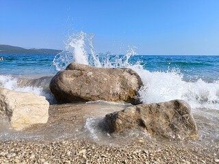 Waves crashing against a rock on the beach of croatia