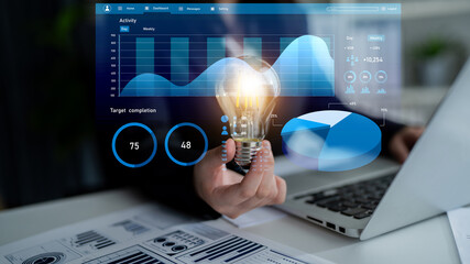 A professional workspace featuring a hand holding a light bulb symbolizing innovative ideas, combined with visual data analysis for informed decision making. Impute