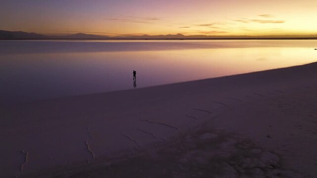 Man standing at Salinas Grandes during sunset