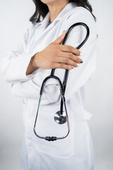 Close-up of female doctor holding stethoscope wearing white lab coat