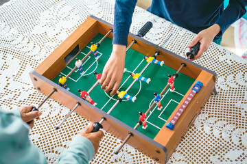 Top view of two people playing foosball on a wooden table stock photo