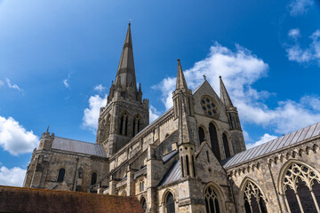 Fototapeta premium Traditional Gothic cathedral with ornate spires and stone facade under blue sky