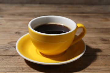 Obraz premium Cup of aromatic coffee on wooden table, closeup