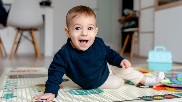 Baby playing on a colorful mat in a cozy room