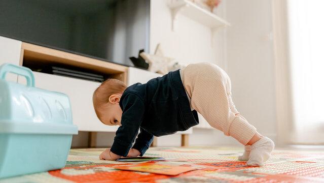 Baby playing on colorful mat with cards