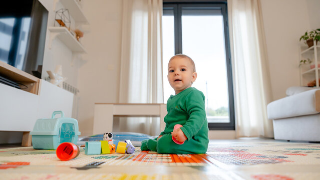 Baby playing on colorful mat with toys