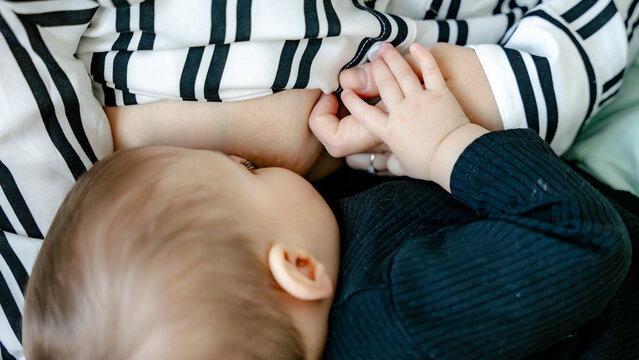 Baby breastfeeding at 7 months with striped blanket