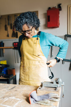 Woman in a restoration workshop adjusting apron